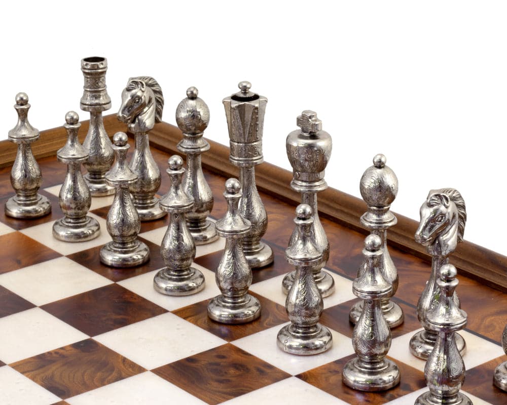 Elegant briarwood and maple chessboard with intricately designed metal chess pieces on display